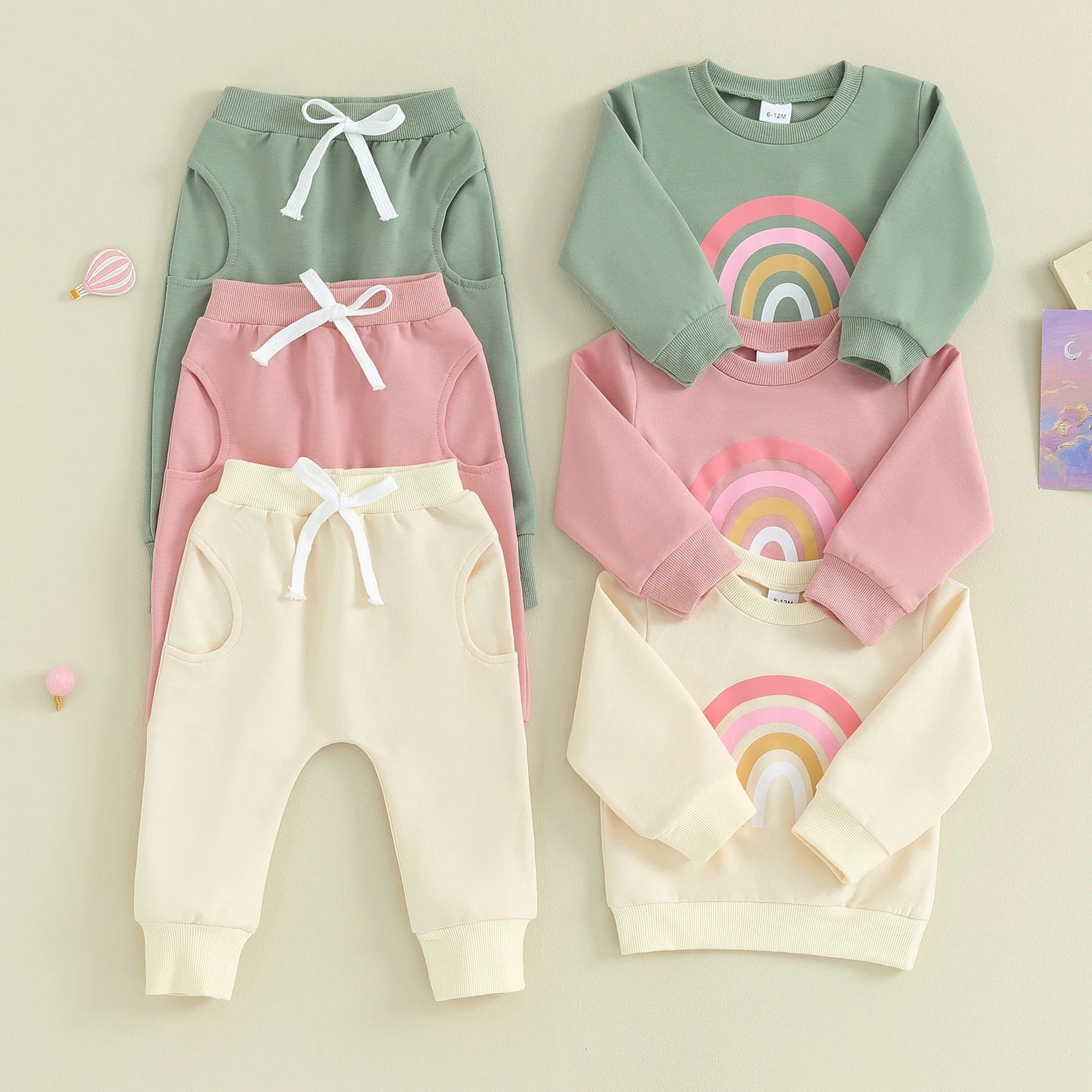 Baby Rainbow Set featuring a long-sleeve top with a cheerful rainbow design and comfy pants with an adjustable drawstring. Available in vibrant colors for everyday adventures.